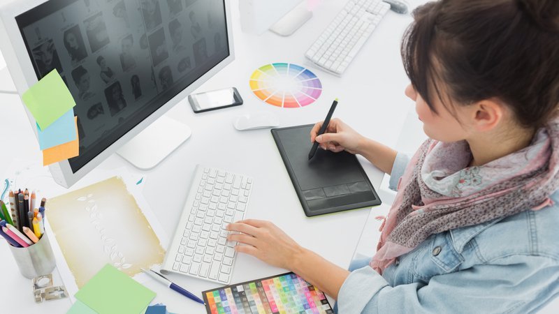 diseñadora trabajando con tableta gráfica frente a ordenador